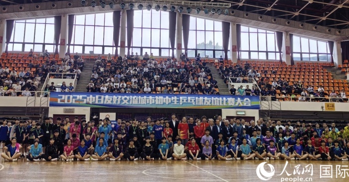 出席2025中日友好交流城市初中生乒乓球友誼比賽大會開幕式的嘉賓與參賽選手等合影留念。人民網記者 陳建軍攝