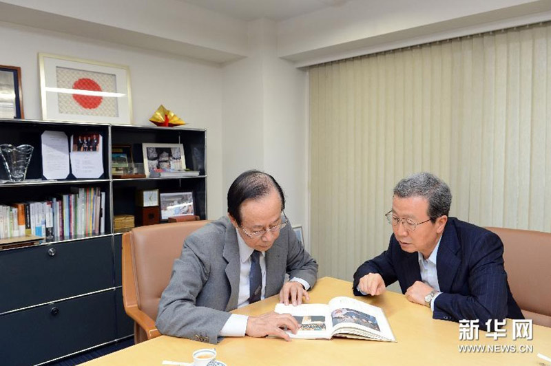 8月13日，在日本东京福田康夫事务所，中国驻日大使程永华（右）与日本前首相福田康夫观看1978年邓小平和福田赳夫友好交往的图片。福田赳夫是福田康夫的父亲，曾于1976年当选日本首相。　　